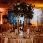 Tavoli degli invitati allestiti con decorazioni floreali e sfere luminose sospese